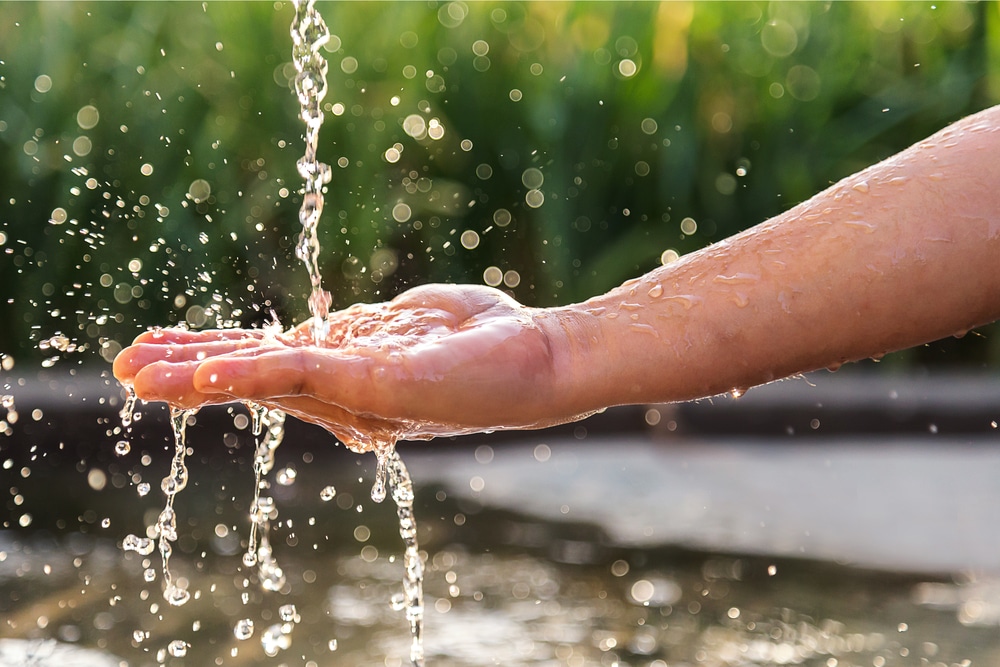 Clean water pours onto a person's hand.